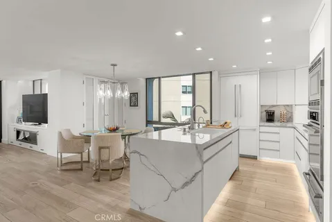 a large white kitchen with a large window and stainless steel appliances