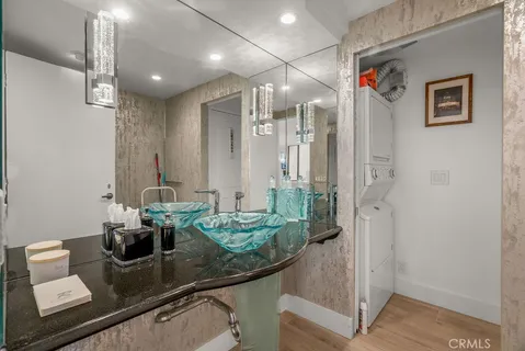 a bathroom with a granite countertop sink a mirror and shower