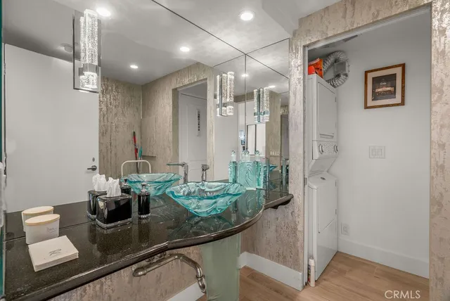 a bathroom with a granite countertop sink a mirror and shower