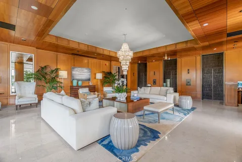 a living room with patio furniture and a chandelier