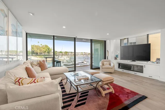 a living room with furniture a large window and a flat screen tv