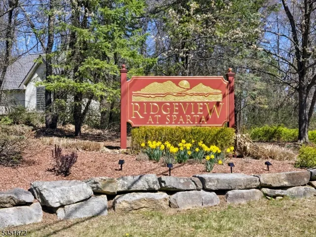 a sign that is sitting in the middle of flowers