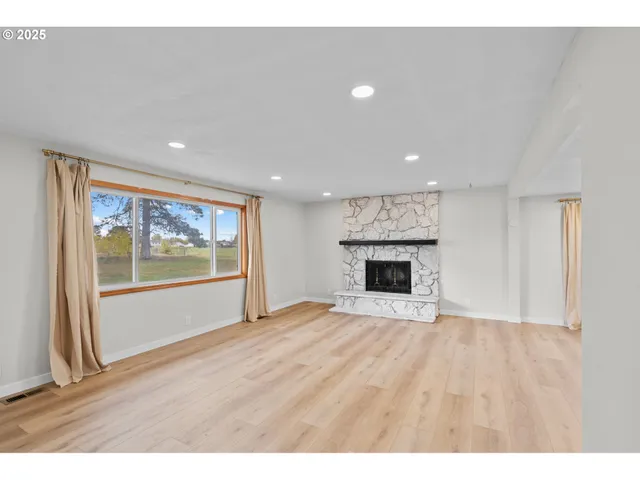 a view of an empty room with a fireplace and a window