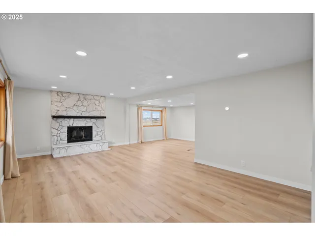 a view of an empty room with a fireplace and a window