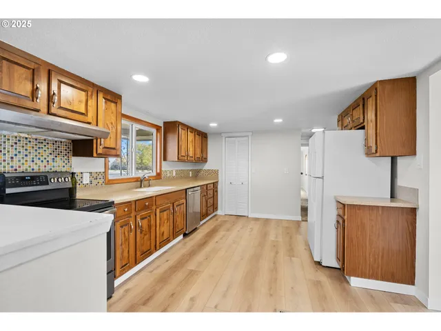 a kitchen with stainless steel appliances granite countertop a sink stove and refrigerator