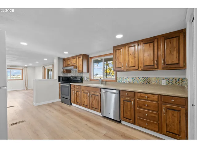 a large kitchen with kitchen island granite countertop a large window