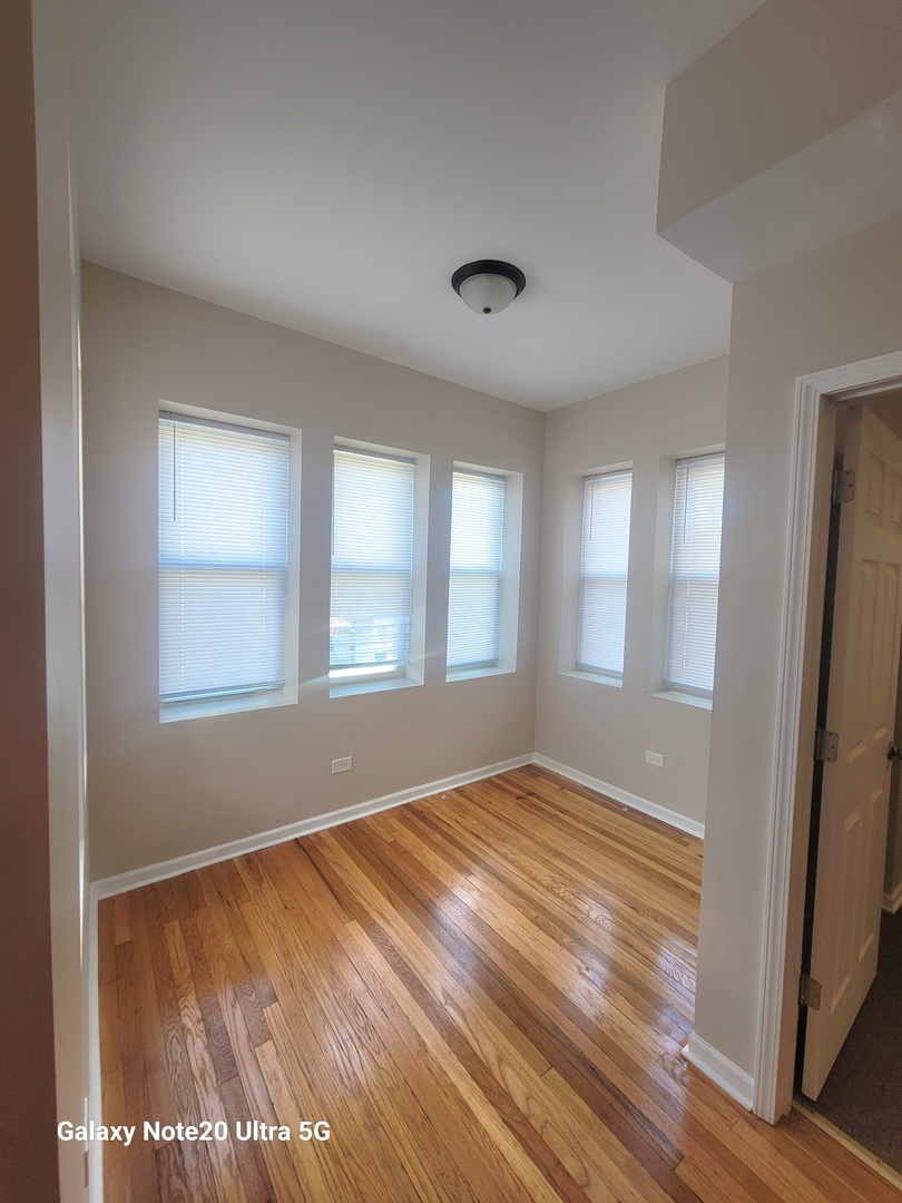 1423 South Drake Avenue, Unit 2 Chicago, IL 60623 - Photo 2 of 9 a view of empty room with wooden floor and fan