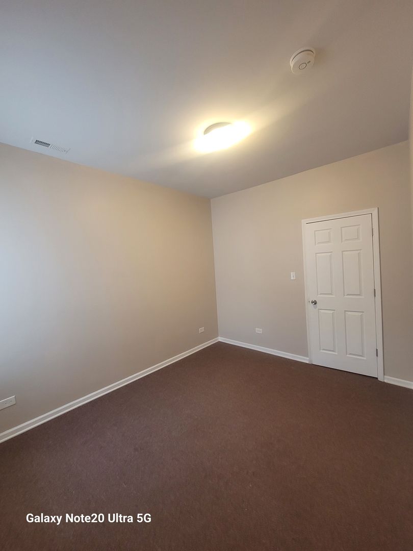 1423 South Drake Avenue, Unit 2 Chicago, IL 60623 - Photo 9 of 9 an empty room with a empty space and windows