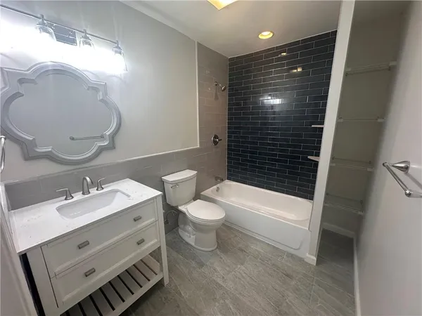 a bathroom with a double vanity sink toilet and shower