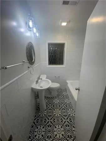 a bathroom with a sink a toilet and mirror