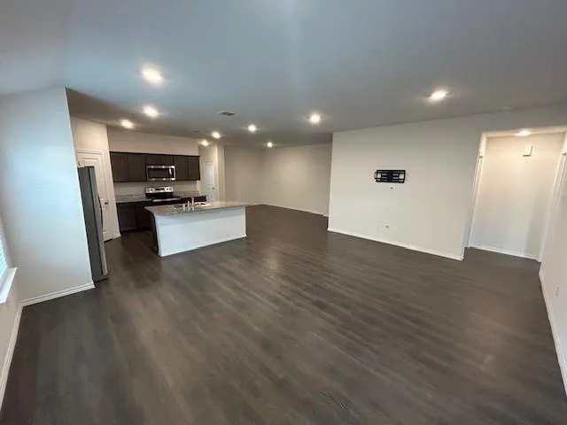 a view of a kitchen with a sink and dishwasher a stove top oven with wooden floor