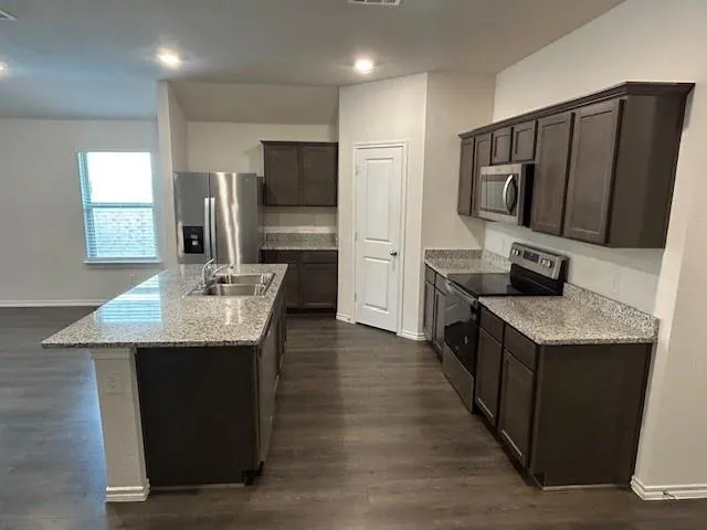a kitchen with stainless steel appliances granite countertop a sink stove and refrigerator