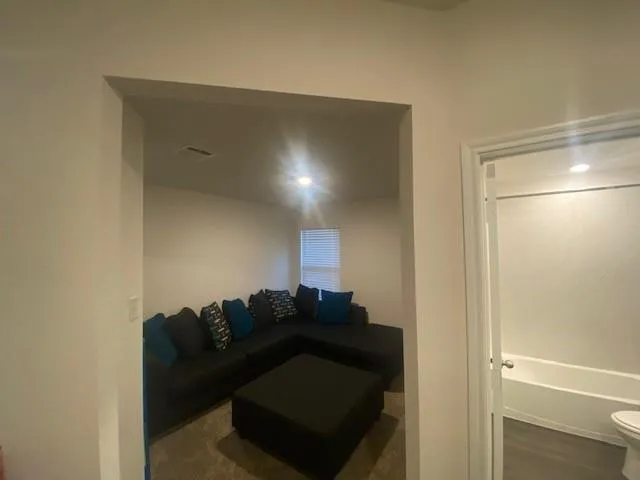 a living room with furniture and a refrigerator