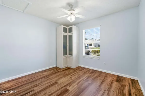 a view of a room with wooden floor and a ceiling fan