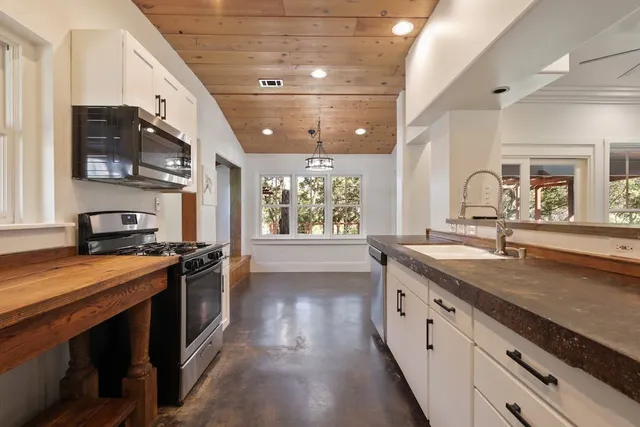 a large kitchen with stainless steel appliances granite countertop a stove and a sink