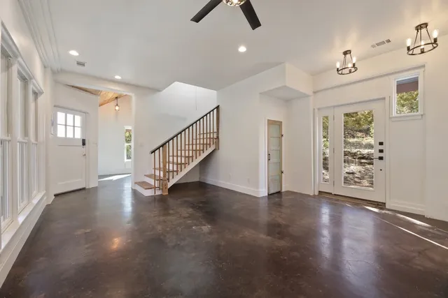 an empty room with wooden floor and ceiling fan