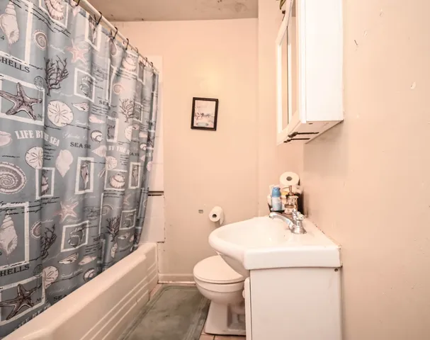 a bathroom with a sink a toilet and shower