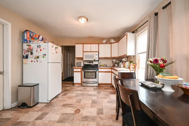 a kitchen with a refrigerator and a dining table