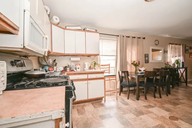 a kitchen with appliances a sink a counter and dining table