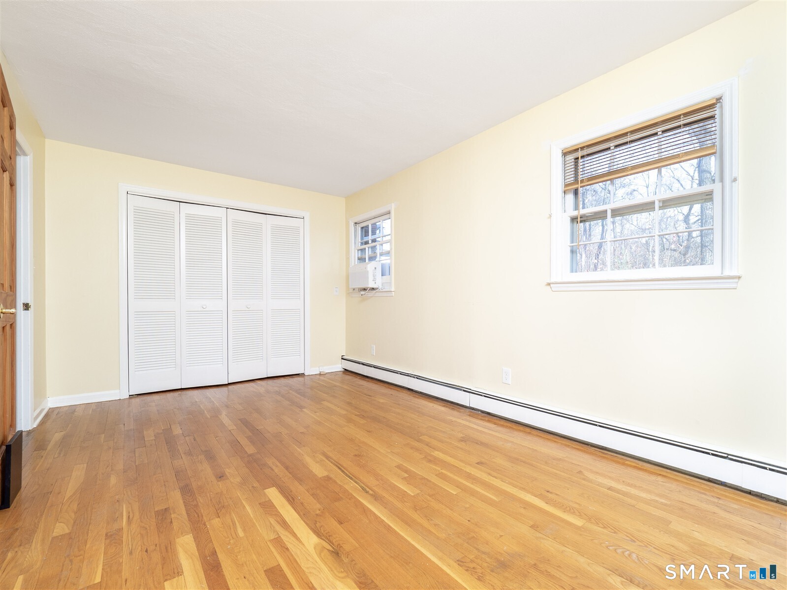 267 Thayer Pond Road Wilton, CT 06897 - Photo 13 of 28 an empty room with wooden floor and windows
