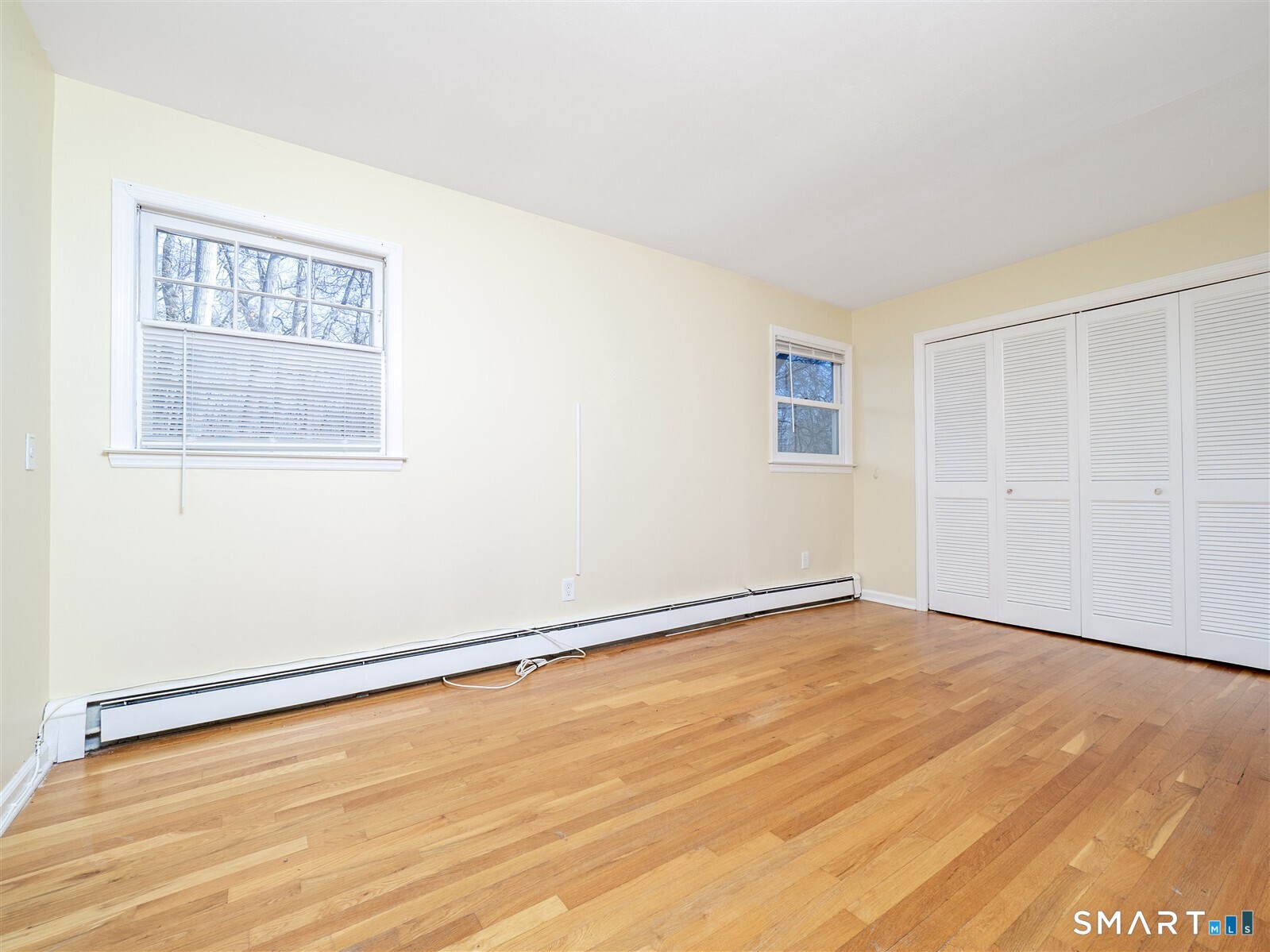 267 Thayer Pond Road Wilton, CT 06897 - Photo 14 of 28 an empty room with wooden floor and windows