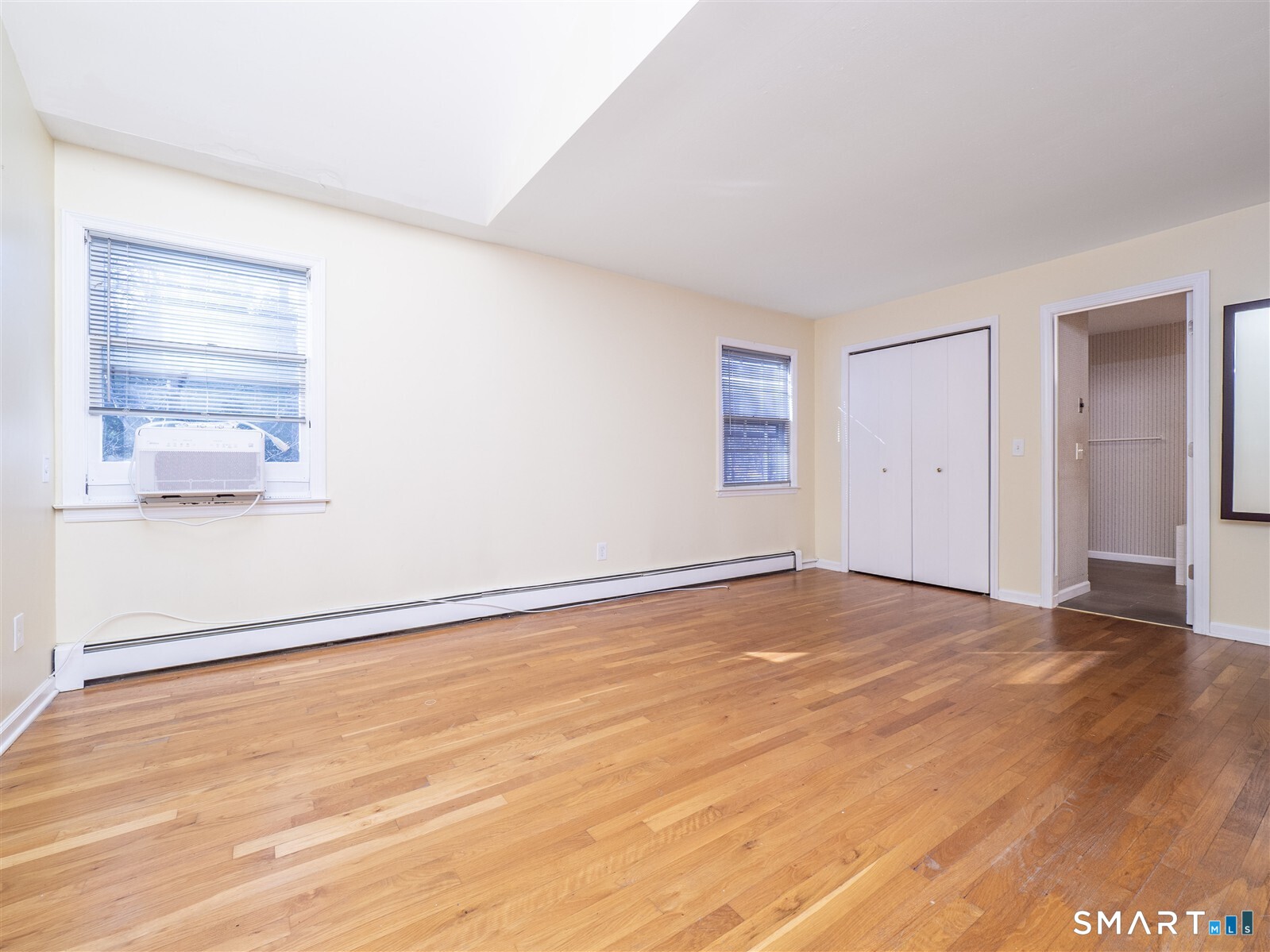 267 Thayer Pond Road Wilton, CT 06897 - Photo 16 of 28 a view of an empty room with wooden floor and a window