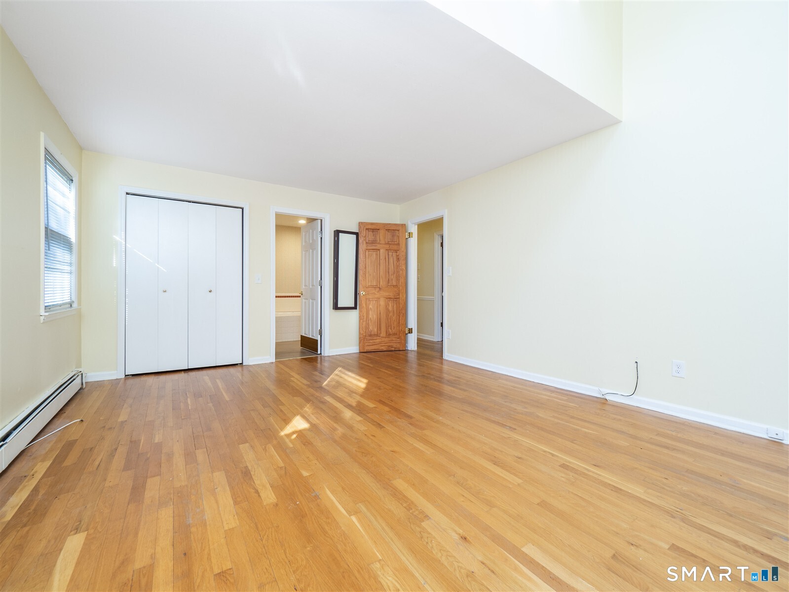 267 Thayer Pond Road Wilton, CT 06897 - Photo 17 of 28 an empty room with wooden floor and windows