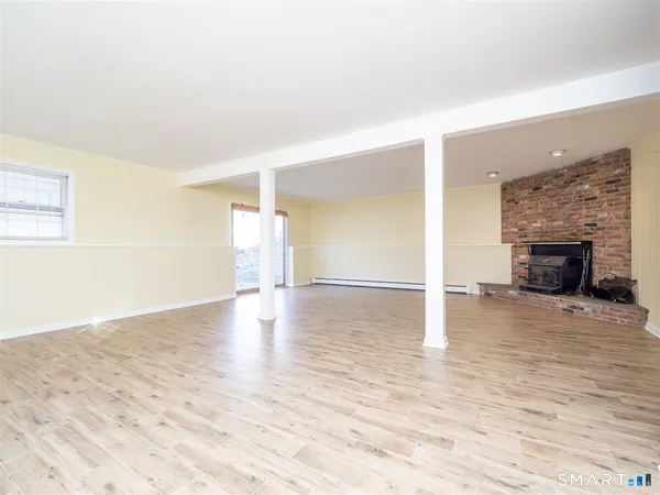 a view of empty room with wooden floor and fireplace