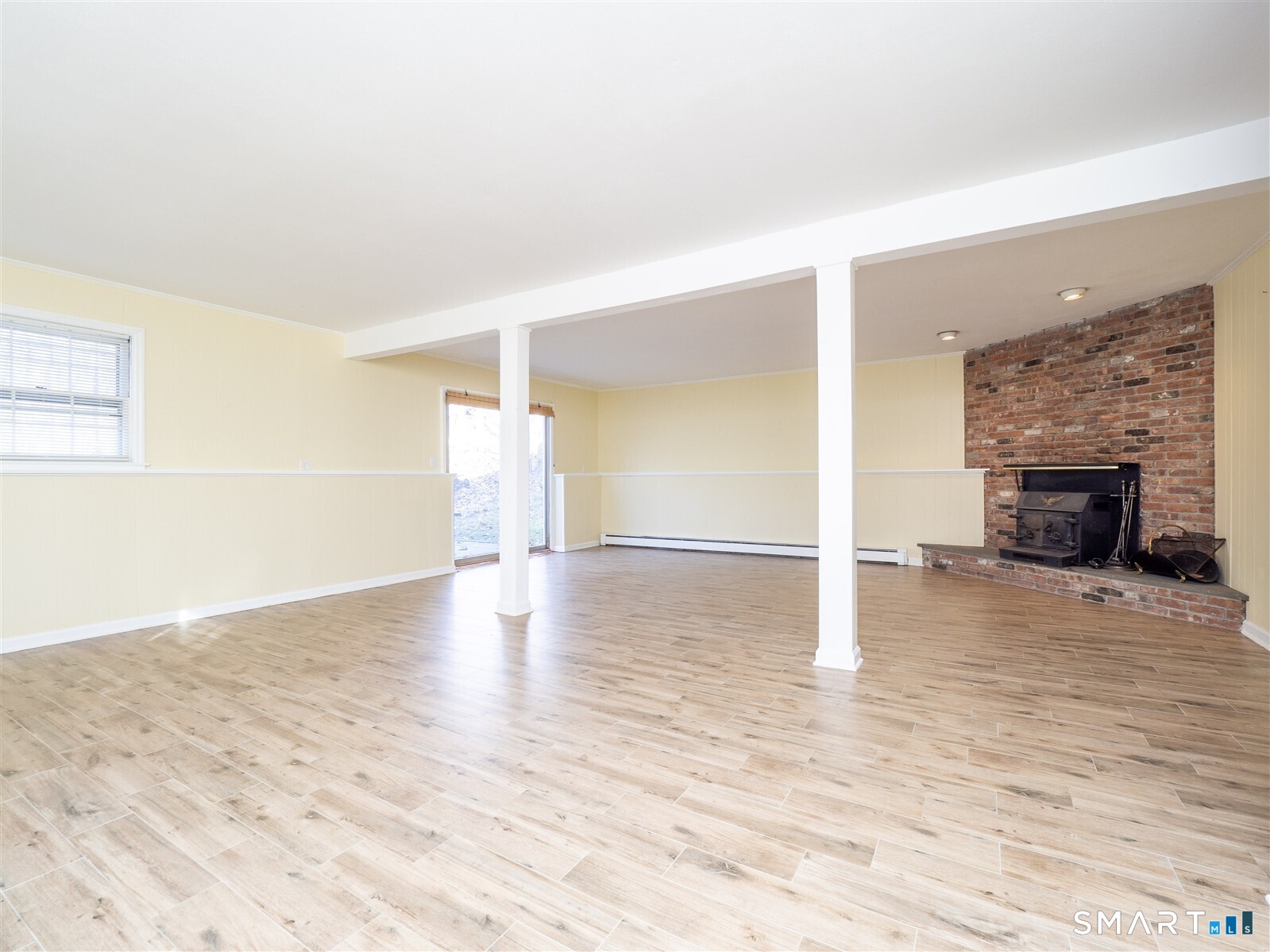 267 Thayer Pond Road Wilton, CT 06897 - Photo 22 of 28 a view of empty room with wooden floor and fireplace