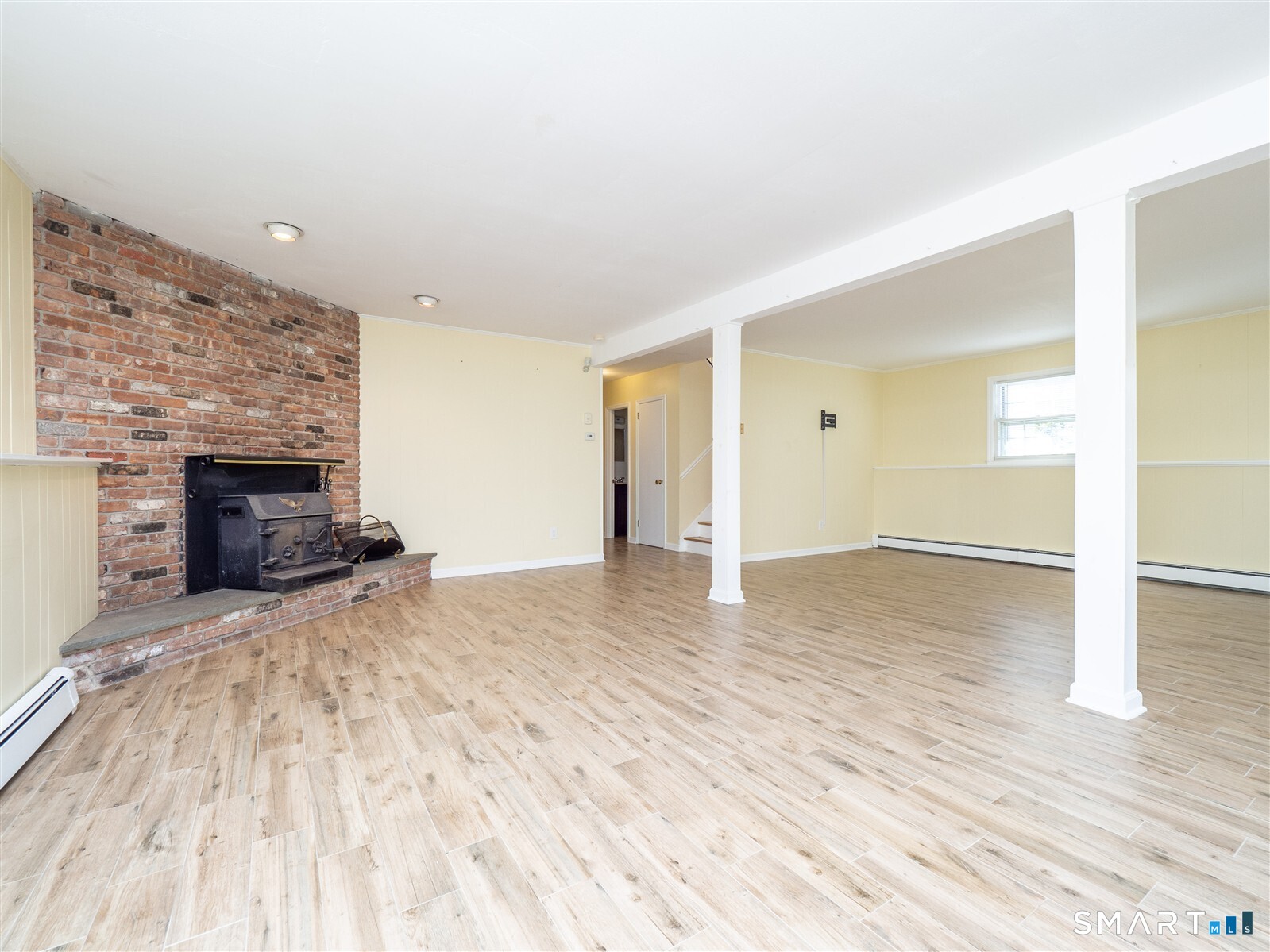267 Thayer Pond Road Wilton, CT 06897 - Photo 23 of 28 a view of empty room with wooden floor and fireplace