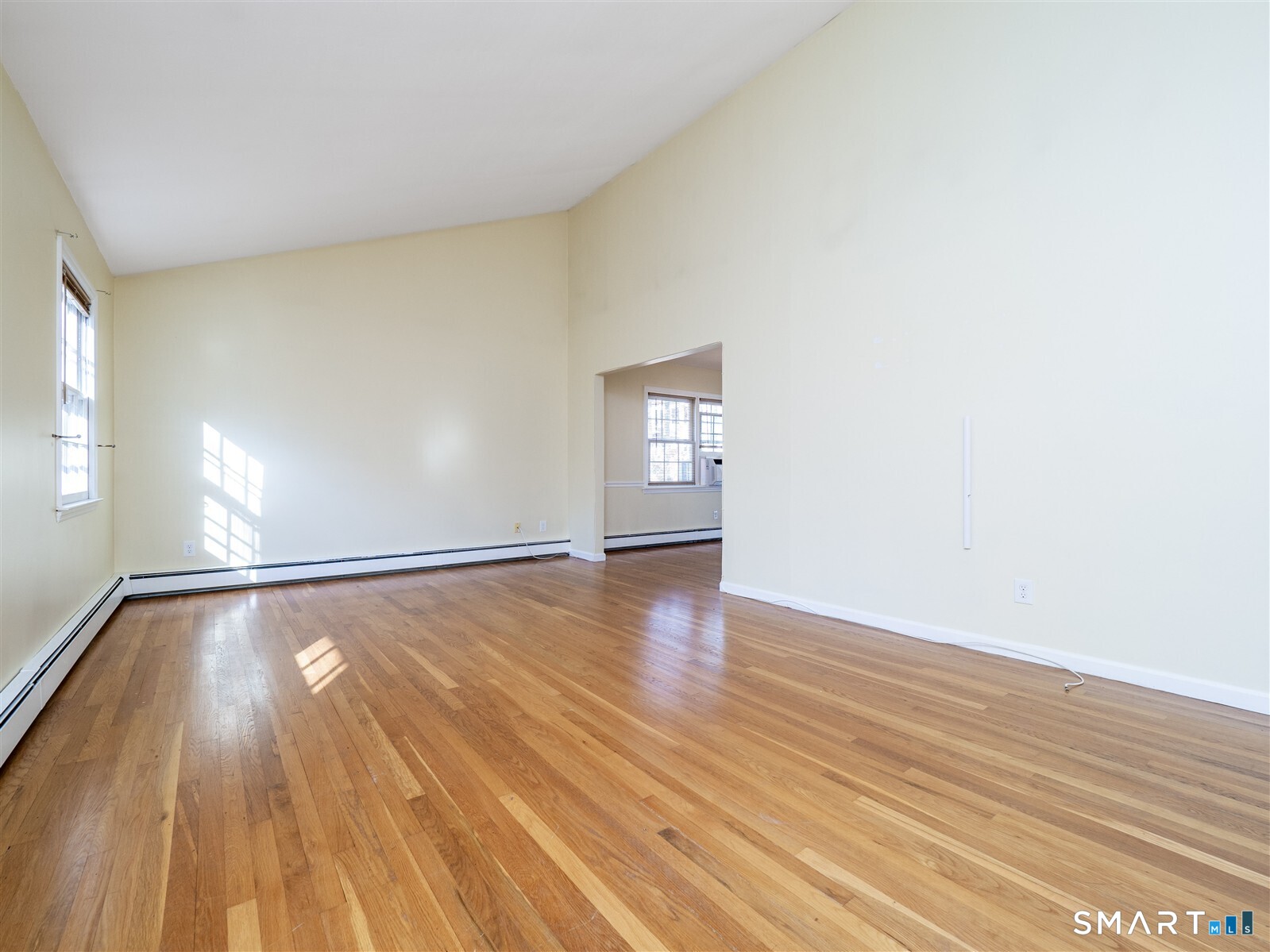267 Thayer Pond Road Wilton, CT 06897 - Photo 5 of 28 an empty room with wooden floor and windows