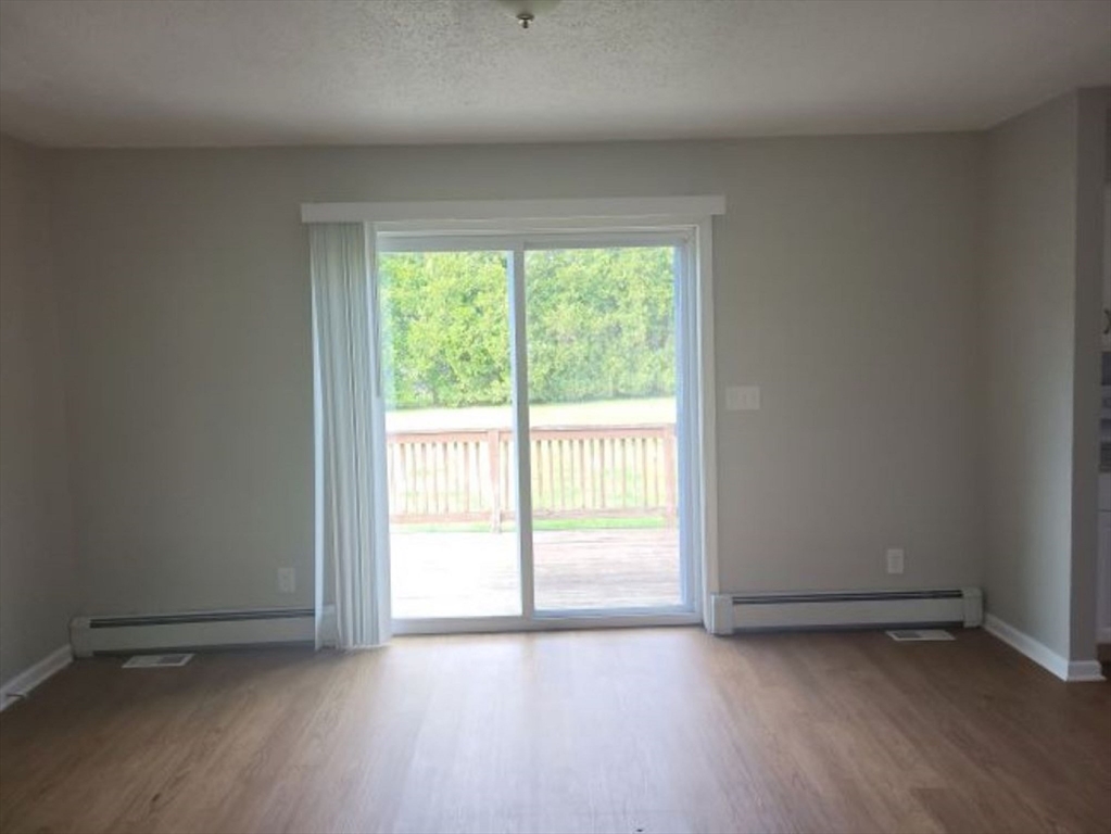 39 Ruggles Street Gilbertville, MA 01031 - Photo 4 of 14 an empty room with wooden floor and windows