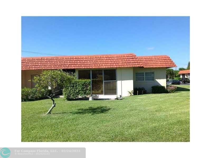 1918 Palmland Drive, Unit 2B Boynton Beach, FL 33436 - Photo 1 of 10 a front view of a house with a yard