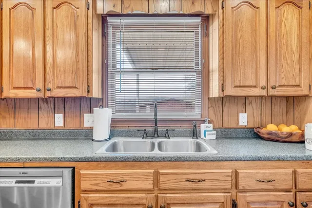 a large kitchen with granite countertop a large counter top stainless steel appliances and cabinets