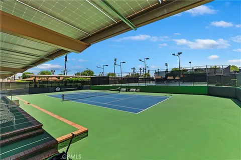 a view of a tennis ground with large trees