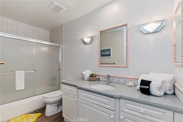 a bathroom with a granite countertop sink a toilet and a mirror
