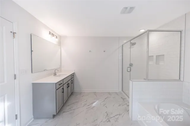 a spacious bathroom with a shower sink and mirror