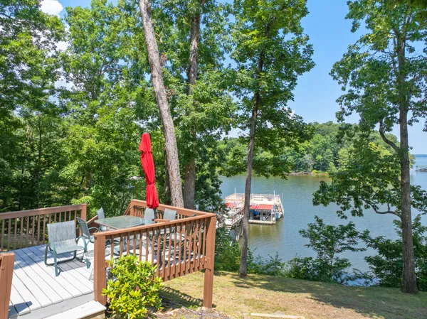 a backyard of a house with lots of green space and lake view