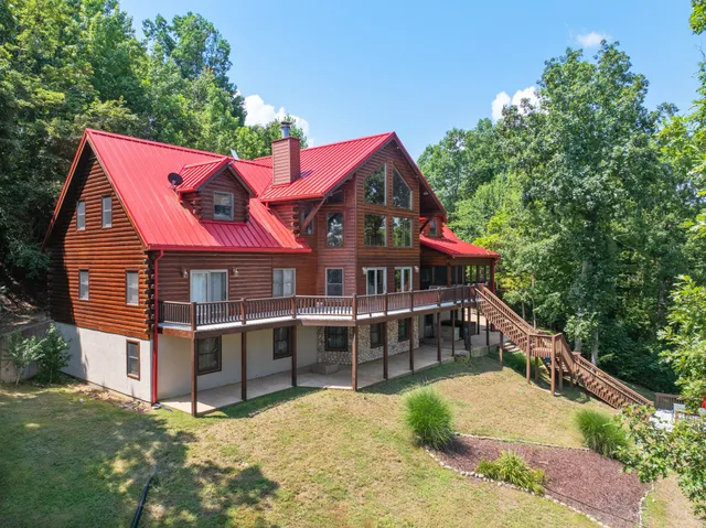 an aerial view of a house with a yard and large trees
