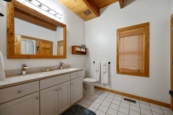 a bathroom with a sink a toilet and a mirror