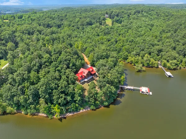 an aerial view of a house with a yard and lake view