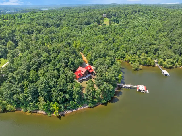 an aerial view of a house with a yard and lake view