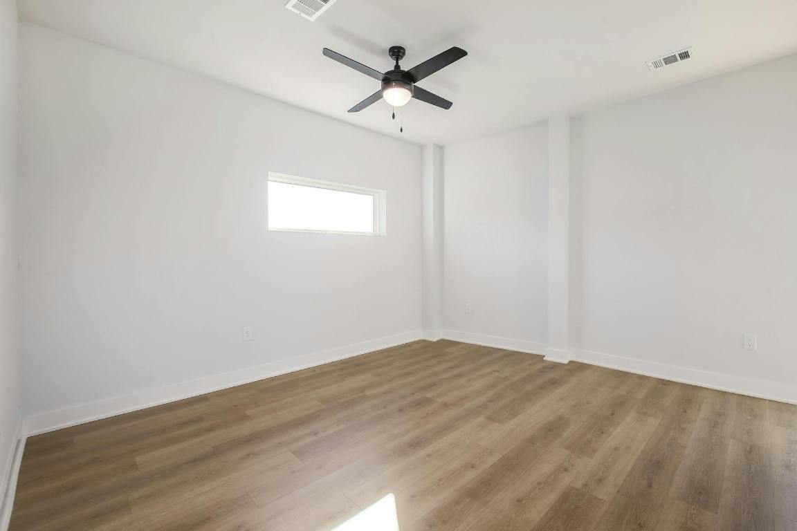 2500 Longview Street, Unit 501 Austin, TX 78705 - Photo 9 of 23 an empty room with wooden floor and ceiling fan
