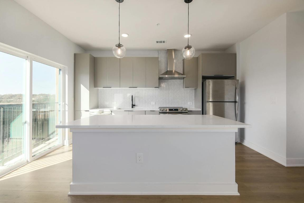 2500 Longview Street, Unit 501 Austin, TX 78705 - Photo 6 of 23 a view of kitchen with kitchen island a stove a sink a center island and wooden floor