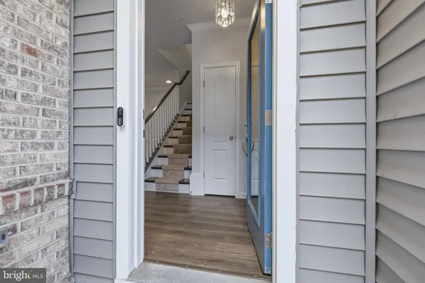 a view of entryway and kitchen with wooden floor