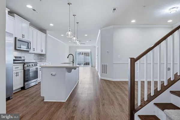 a kitchen with stainless steel appliances a refrigerator a stove and white cabinets