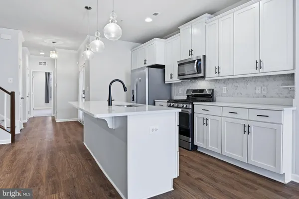 a kitchen with stainless steel appliances granite countertop a sink a refrigerator and a stove