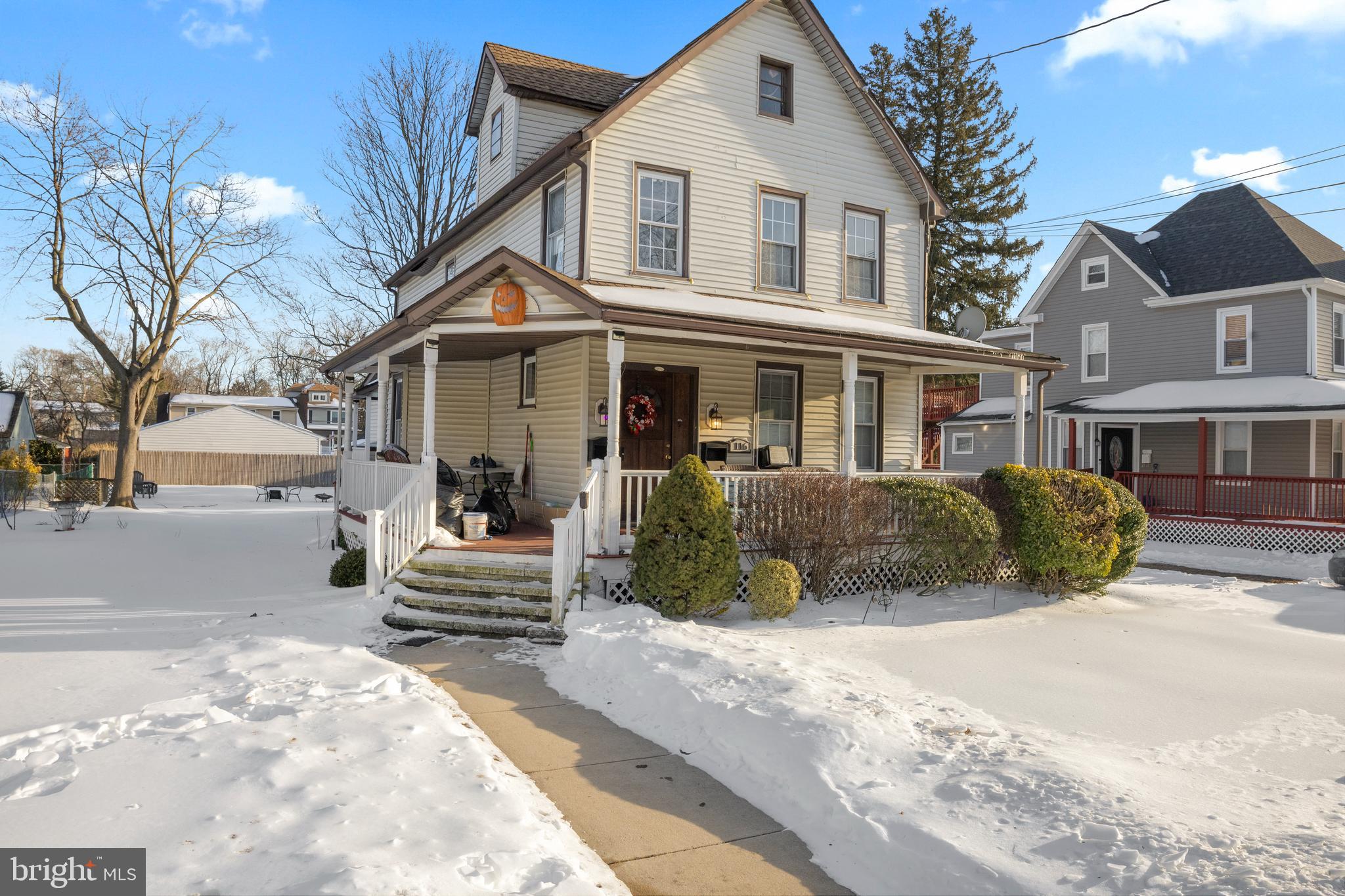 a view of a white house with a large windows next to a road