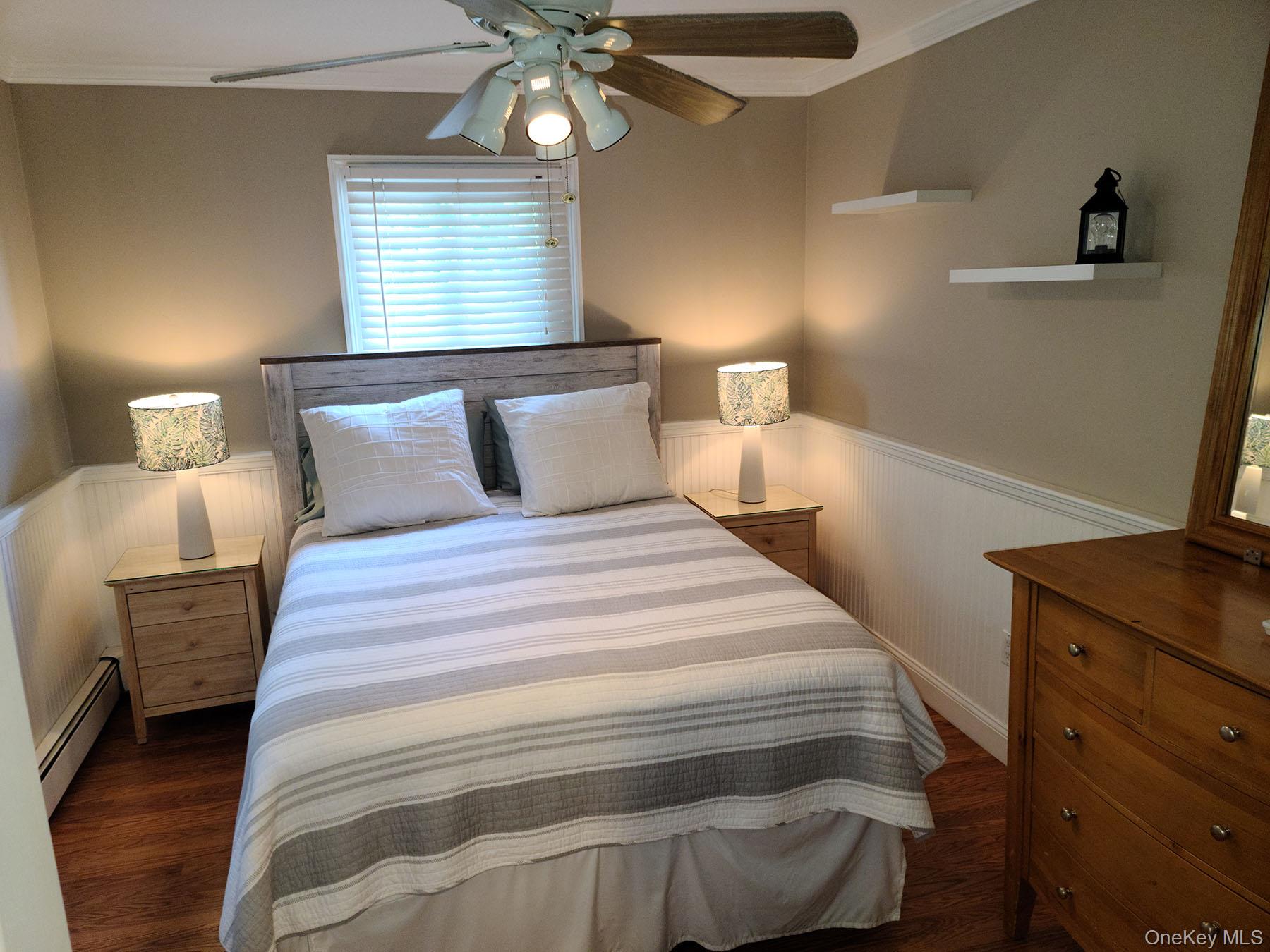 62 Canoe Place Road, Unit 627 Hampton Bays, NY 11946 - Photo 11 of 27 a bedroom with a bed and a chandelier