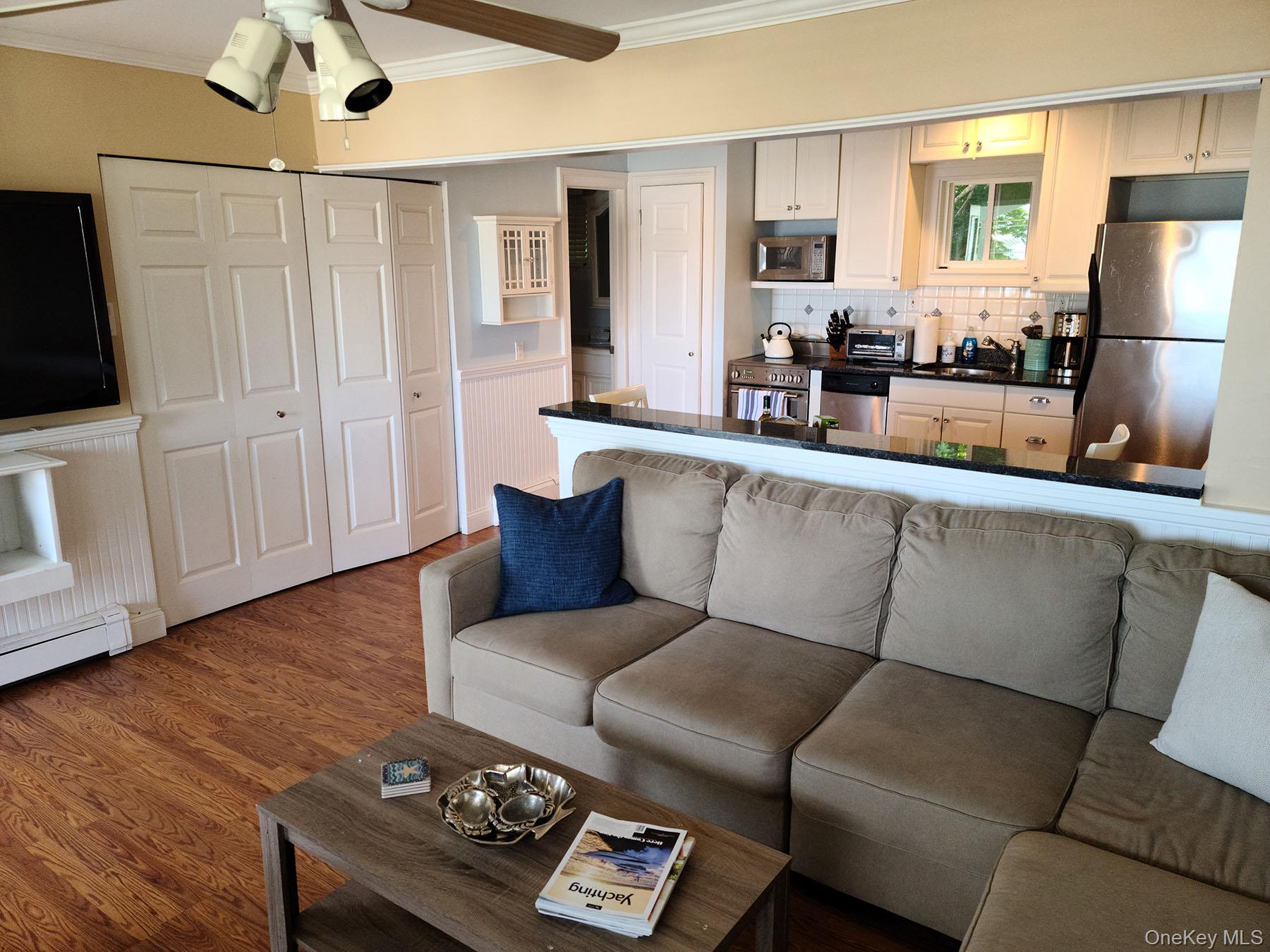 62 Canoe Place Road, Unit 627 Hampton Bays, NY 11946 - Photo 16 of 27 a living room with furniture and a flat screen tv